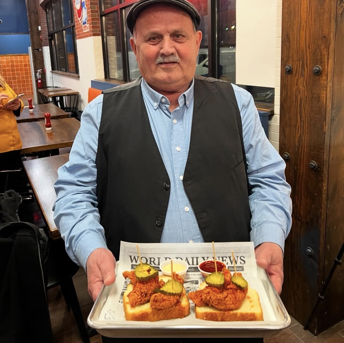Baba serving Babs Hot Chicken to guests